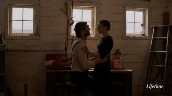 Ryan McPartlin and a woman standing together in a rustic interior